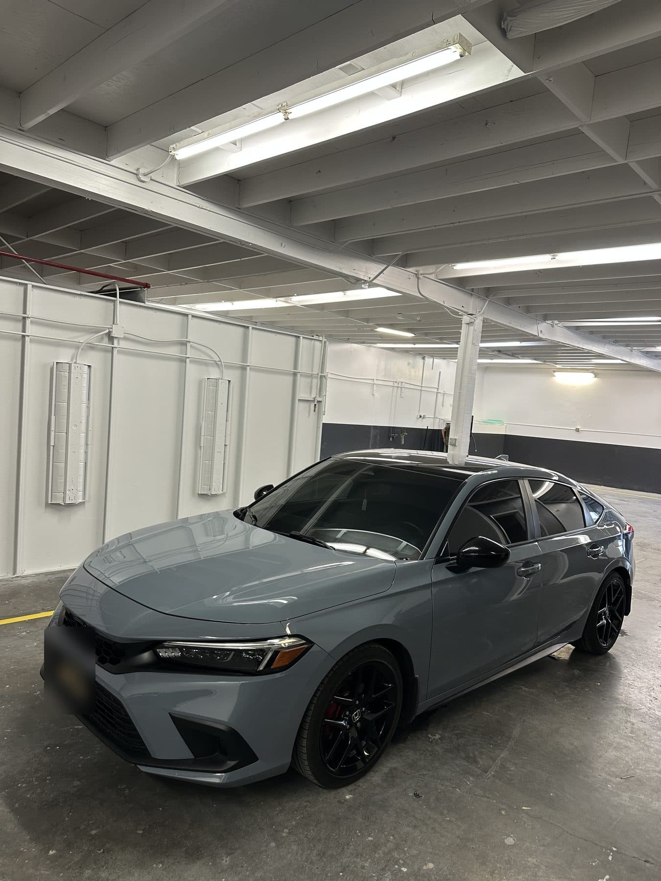 Gray Honda Civic with black wheels, front three-quarter view
